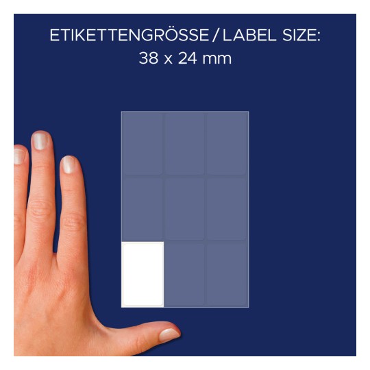 Kuva esittää kättä tarralevyn vieressä, jonka mitat ovat 38 x 24 mm. Levyllä on ruudukkoasettelu, ja yksi tyhjä tarra-alue on korostettu valkoisella alhaalla vasemmalla.