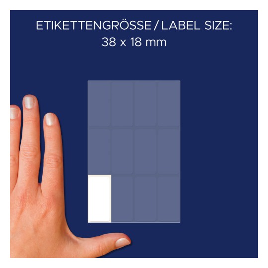 Kuva näyttää käden etikettilakanan vieressä, jossa etiketin koko on ilmoitettu olevan 38 x 18 mm. Tausta on tummansininen, ja etiketit on järjestetty ruudukkokuvioon.