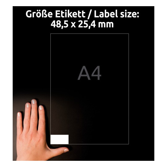 Kuva näyttää A4-kokoisen paperin, jossa on etiketti, jonka koko on 48,5 x 25,4 mm, sekä käden koon vertailuksi.