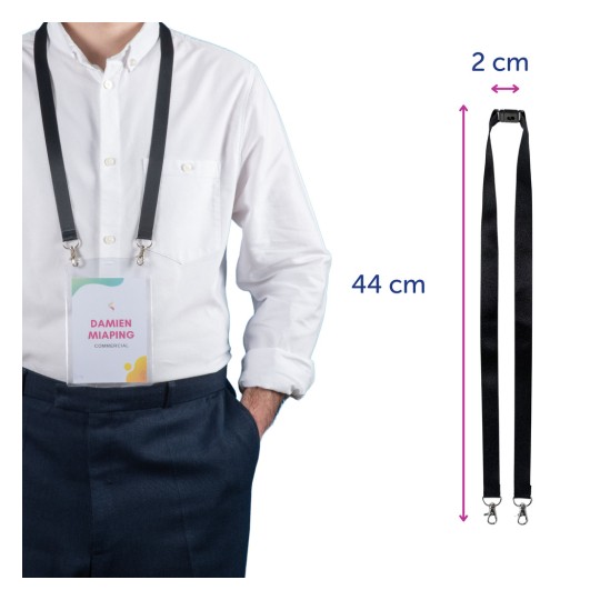 Yksilö, jolla on valkoinen paita, seisoo kädet taskuissa ja esittelee mustaan kaulanauhaan kiinnitettyä nimikylttiä. Kyltissä on nimi 'DAMIEN MIAPING' ja sana 'COMMERCIAL'. Kaulanauhan mitat ovat 44 cm pituudeltaan ja 2 cm leveydeltään.
