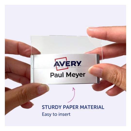 Kuvassa henkilö pitelee nimikylttiä, jossa on nimi 'Paul Meyer' ja Avery-logo, mikä osoittaa sen olevan valmistettu tukevasta paperimateriaalista ja sen olevan helppo asettaa paikoilleen.