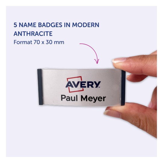 Kuvassa henkilö pitää nimikylttiä, jossa lukee 'Avery Paul Meyer', korostaen viittä modernin antrasiitin väristä nimikylttiä, joiden mitat ovat 70 x 30 mm.