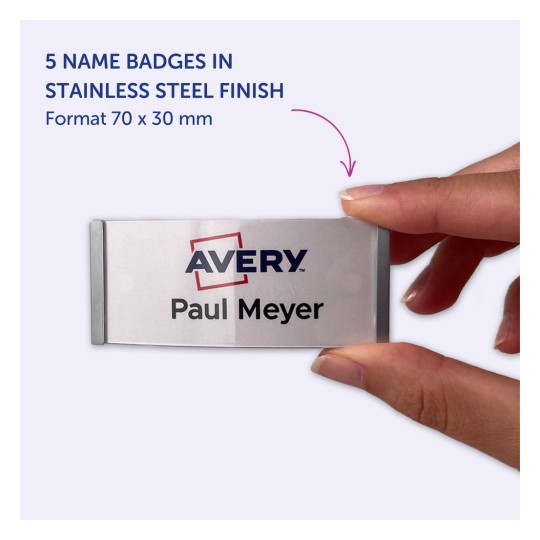 Kuvassa on henkilö, joka pitää kädessään nimikylttiä, jossa lukee 'Avery Paul Meyer'. Tuote on viiden nimikyltin setti ruostumattomasta teräksestä, ja niiden mitat ovat 70 x 30 mm.