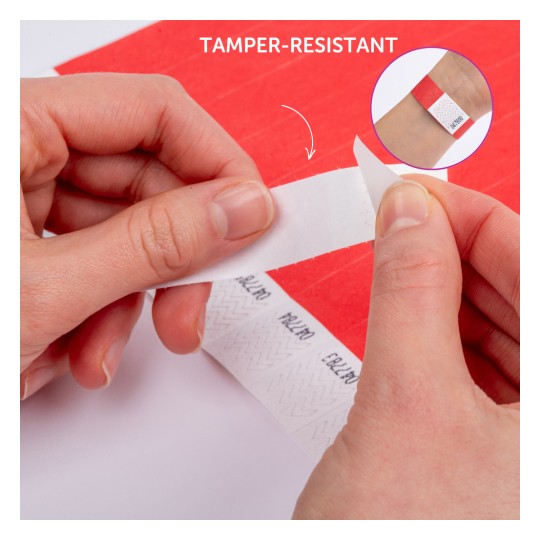 Kuva, jossa kädet irrottavat tuunauksen kestävää tarraa punaiselta pinnalta. Tarrassa on kuvio ja ylhäällä lukee 'TAMPER-RESISTANT'. Lähikuvassa tarra näkyy käytettävän ranteessa.