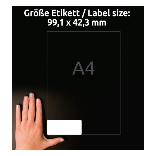 Kuvassa näkyy käsi läpinäkyvän tarran vieressä, joka ilmoittaa kokomääritelmät. Siinä lukee "Größe Etikett / Label size: 99,1 x 42,3 mm" ja keskelle on merkitty "A4".
