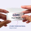 Kuvassa henkilö pitelee nimikylttiä, jossa on nimi 'Paul Meyer' ja Avery-logo, mikä osoittaa sen olevan valmistettu tukevasta paperimateriaalista ja sen olevan helppo asettaa paikoilleen.