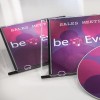 Kuvassa on kaksi CD-koteloa, joissa lukee "Sales Meeting", ja levy, jossa on värikäs muotoilu. Muotoilussa on ympyröitä vaaleanpunaisen ja violetin sävyissä sekä teksti "beEven".