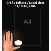Kuvassa näkyy käsi, joka on sijoitettu etiketin viereen, jonka mitat ovat 63,5 x 42,3 mm, A4-referenssin rinnalla. Tausta on musta.